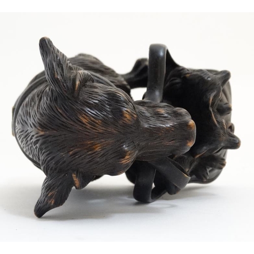 813 - A 21st carved black forest inkwell formed as a dachshund dog with hinged head and holding a satchel ... 