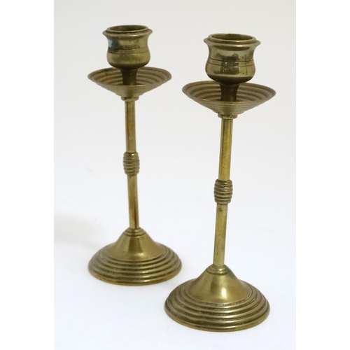 817 - A pair of late 19thC cast and turned brass candlesticks bearing indistinct marks under 6 1/8'' high