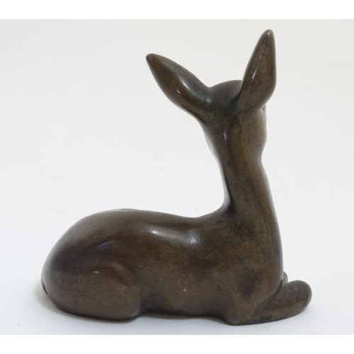 826 - A mid 20thC cast solid bronze figure of a seated doe deer. 3 1/2'' high