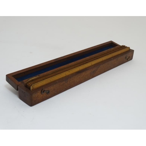 828 - A mahogany box opening to reveal 6 boxwood rulers by ' Davis & Son Derby ' , ' Bemrose & Sons Derby ... 