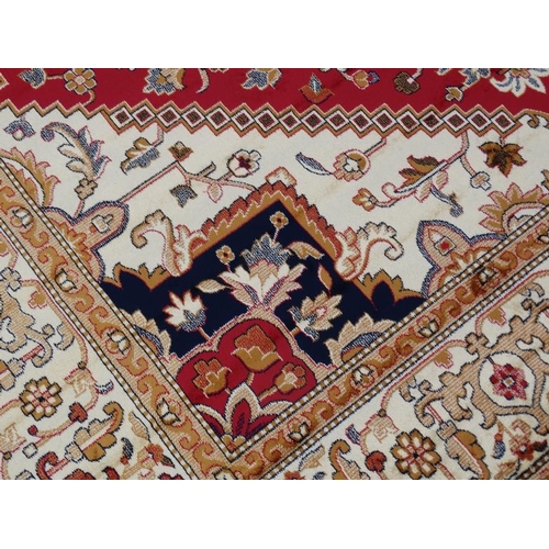 83 - Carpet / Rug : A machine made woollen rug with red and buff central ground, surrounded with midnight... 