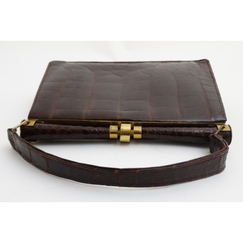 831 - A vintage crocodile effect leather brown ladies single handle handbag, with brass hardware and frame... 