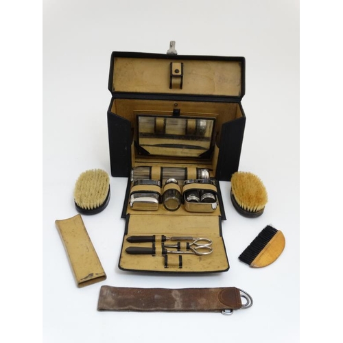 846 - An early - mid 20thC black leather and pigskin lined Gentleman's travelling vanity set with ebony an... 