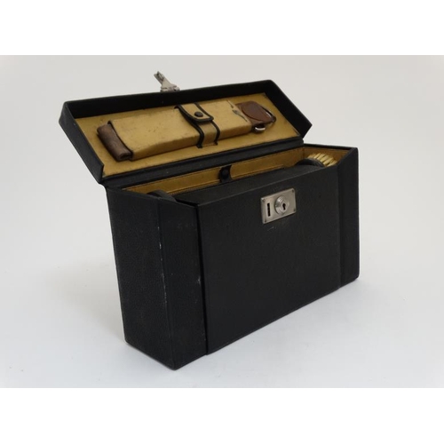 846 - An early - mid 20thC black leather and pigskin lined Gentleman's travelling vanity set with ebony an... 