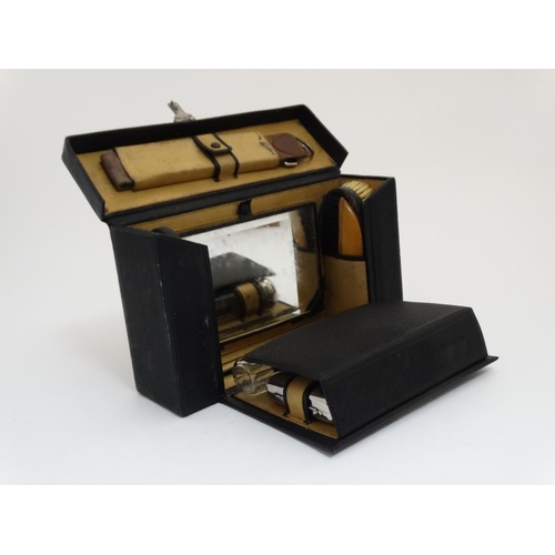 846 - An early - mid 20thC black leather and pigskin lined Gentleman's travelling vanity set with ebony an... 