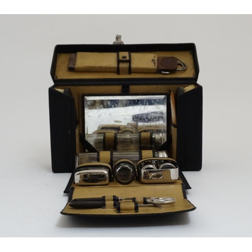 846 - An early - mid 20thC black leather and pigskin lined Gentleman's travelling vanity set with ebony an... 