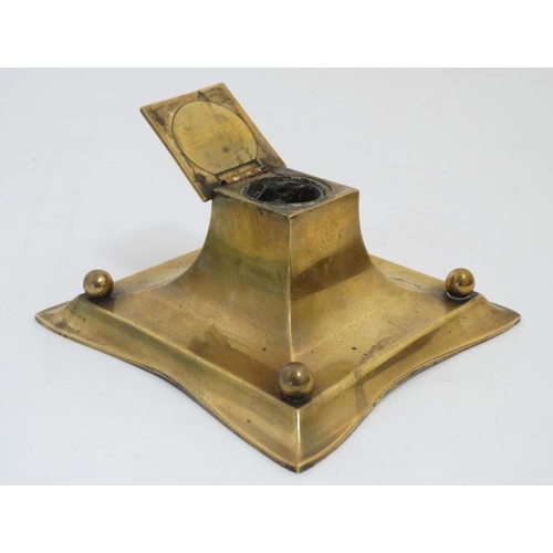 877 - A 19thC cast brass inkwell with pen rests, the centre hinging open to reveal glass lined inkstand. 6... 