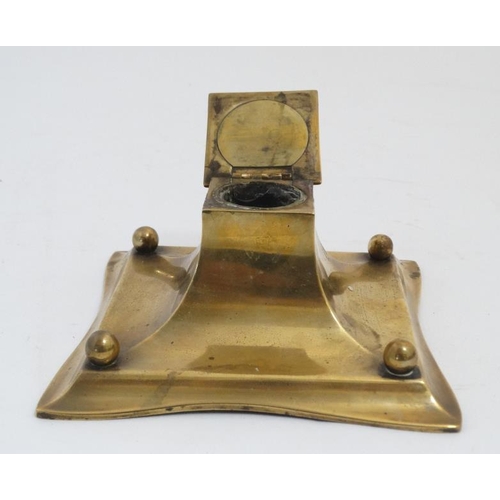 877 - A 19thC cast brass inkwell with pen rests, the centre hinging open to reveal glass lined inkstand. 6... 