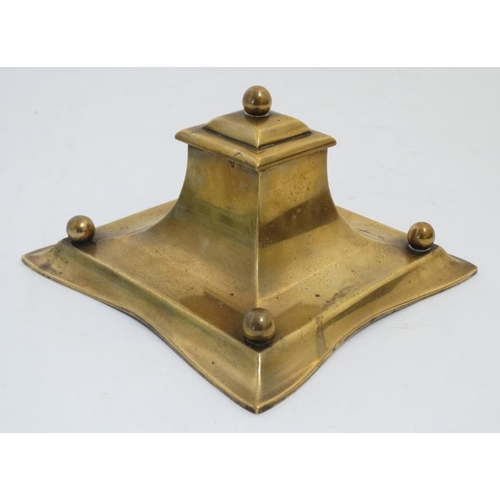 877 - A 19thC cast brass inkwell with pen rests, the centre hinging open to reveal glass lined inkstand. 6... 