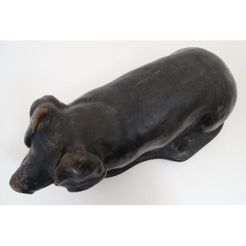 891 - A mid / late 20thC black painted reconstituted stone model of a recumbent pig 19 1/2'' long x 9 1/4'... 