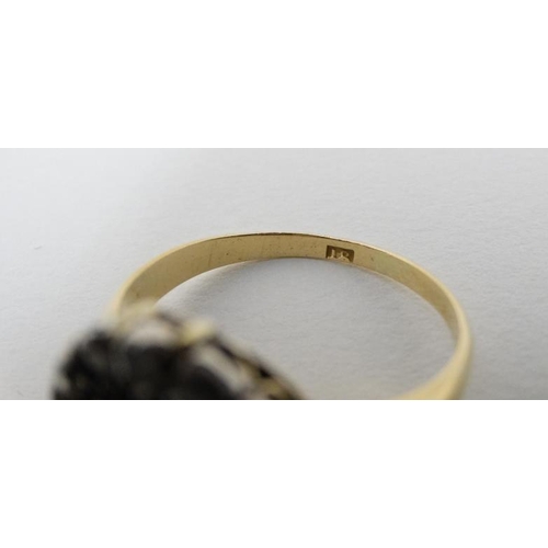 932 - An 18ct gold ring set with central sapphire bordered by diamonds