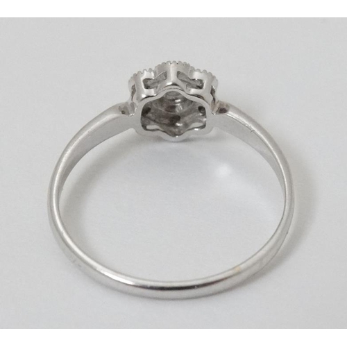 934 - A 14k  white gold ring set with diamonds in a daisy setting