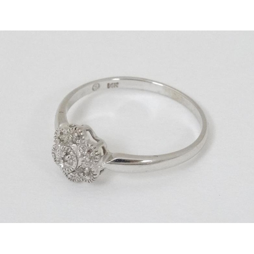 934 - A 14k  white gold ring set with diamonds in a daisy setting