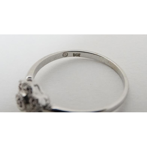 934 - A 14k  white gold ring set with diamonds in a daisy setting