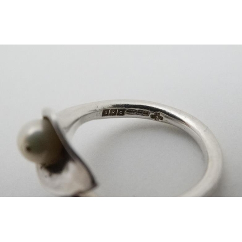 937 - A hallmarked silver ring formed as a stylised calla lily with pearl decoration. Maker ARC