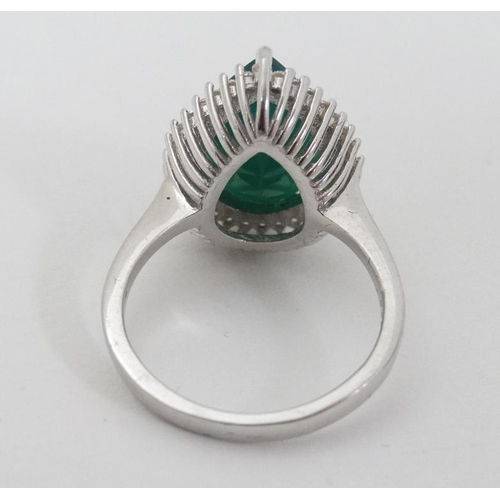 949 - A silver ring set with green stone to top bordered by white stones