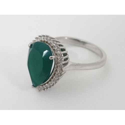 949 - A silver ring set with green stone to top bordered by white stones