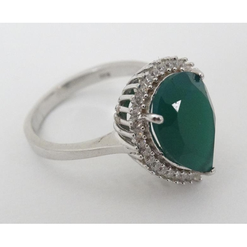 949 - A silver ring set with green stone to top bordered by white stones