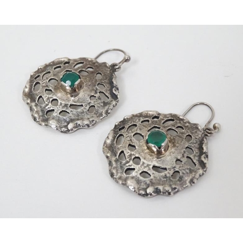 954 - A pair of silver drop earrings of abstract form set with central green stone. 1 1/4'' wide