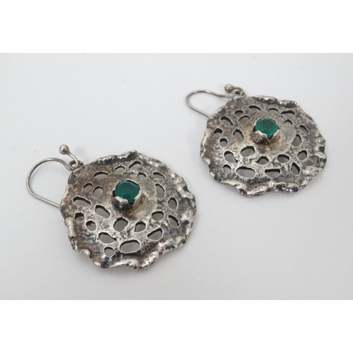 954 - A pair of silver drop earrings of abstract form set with central green stone. 1 1/4'' wide