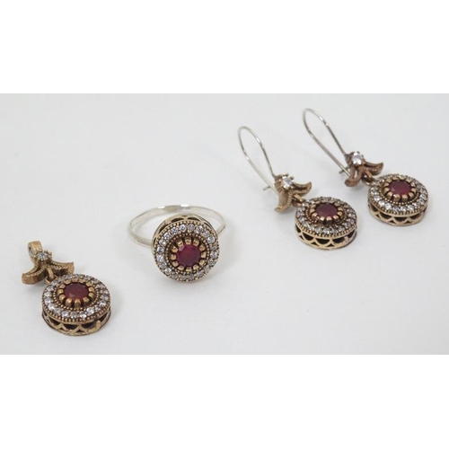 955 - A suite of silver and silver gilt jewellery comprising ring, pendant and earrings all set with red a... 