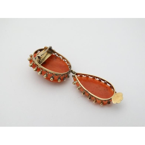 961 - A yellow metal brooch set with carved coral cameo like decoration with drop section under set with s... 