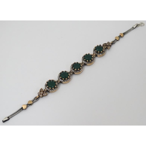 964 - A silver bracelet set with green and white stones with gilt decoration