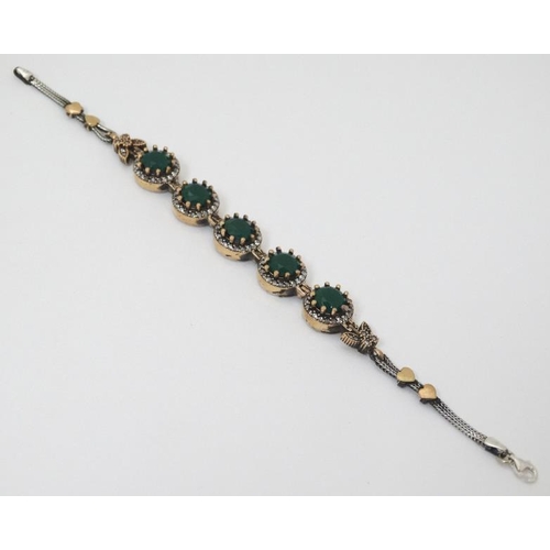 964 - A silver bracelet set with green and white stones with gilt decoration