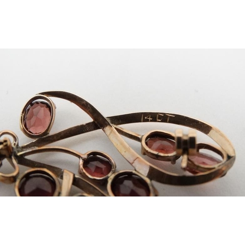 969 - A yellow metal brooch set with 8 garnets. 2'' high