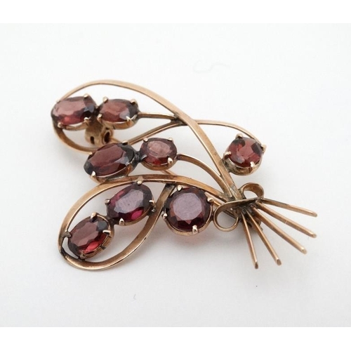 969 - A yellow metal brooch set with 8 garnets. 2'' high