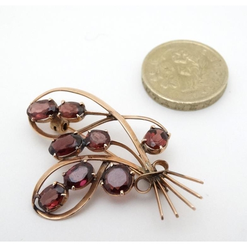 969 - A yellow metal brooch set with 8 garnets. 2'' high