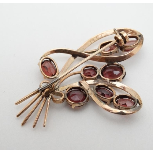 969 - A yellow metal brooch set with 8 garnets. 2'' high