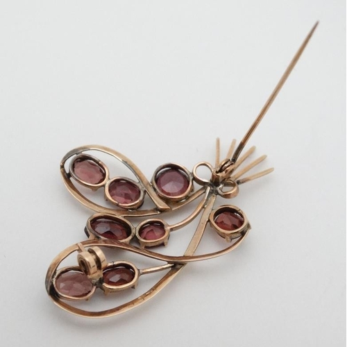 969 - A yellow metal brooch set with 8 garnets. 2'' high