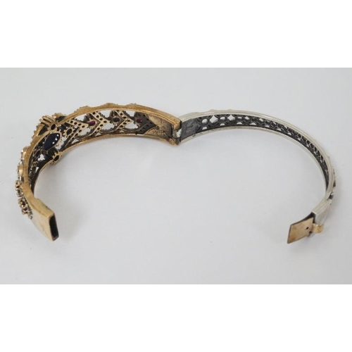 977 - A silver bracelet with silver gilt decoration and set with blue red and white stones