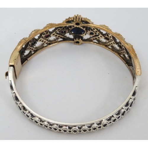 977 - A silver bracelet with silver gilt decoration and set with blue red and white stones