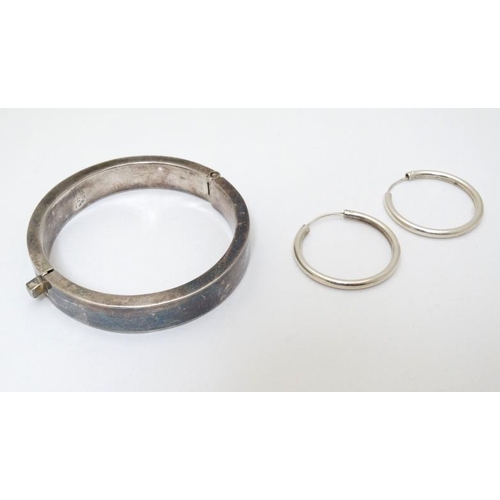 984 - A Mexican silver bracelet of bangle form together with a pair of silver hoop earrings