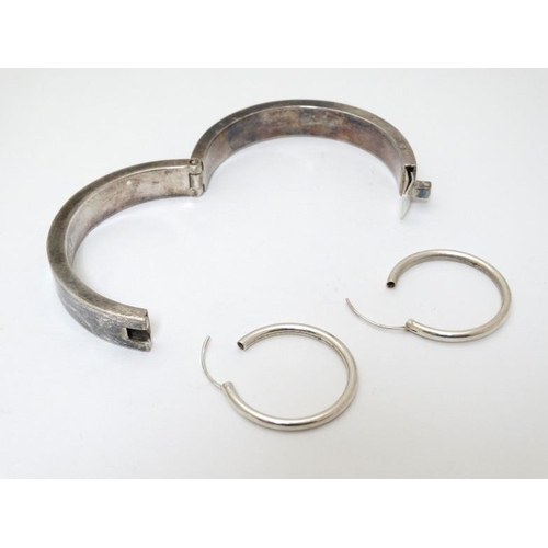 984 - A Mexican silver bracelet of bangle form together with a pair of silver hoop earrings