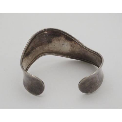 999 - A silver bracelet of bangle form