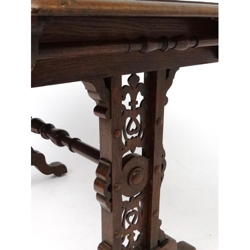 188 - A 19thC Elizabethan Revival oak writing table, with frieze drawer and decorative trestle ends. 42 3/... 