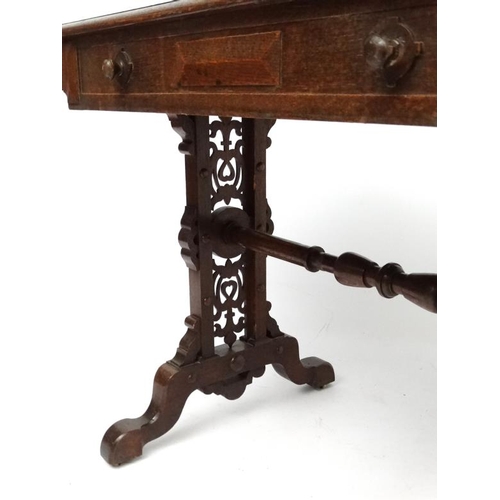 188 - A 19thC Elizabethan Revival oak writing table, with frieze drawer and decorative trestle ends. 42 3/... 