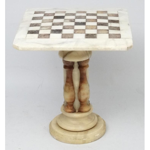 220 - A 20thC onyx engraved marble veined games table with checker board top on pedestal column 23 1/2'' l... 