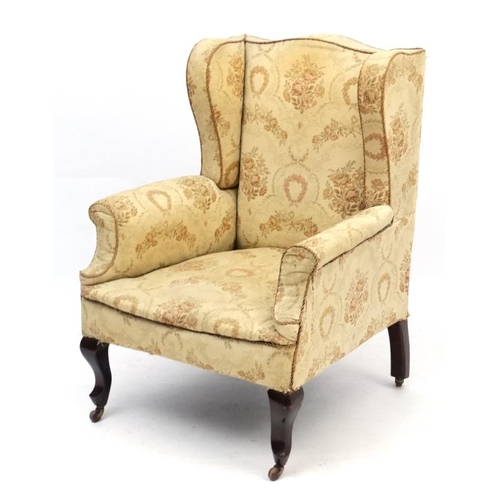 254 - An early - mid 20thC upholstered wingback armchair 39 1/2'' high  Please Note -  we do not make refe... 