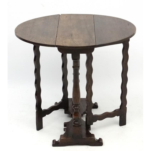 255 - An early - mid 20thC oak peg jointed oval drop flap occasional table with twin gatelegs 25 3/4'' hig... 