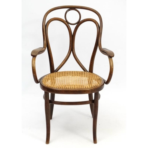 261 - A Thonet bentwood open armchair with caned seat and  bears  label for '  Heal & Son 196 Tottenham Co... 