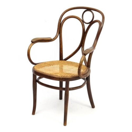 261 - A Thonet bentwood open armchair with caned seat and  bears  label for '  Heal & Son 196 Tottenham Co... 