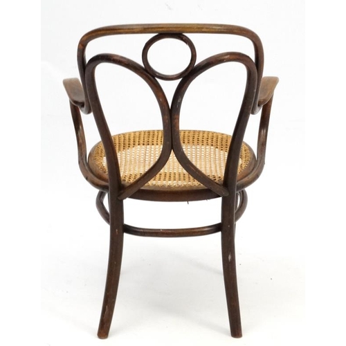 261 - A Thonet bentwood open armchair with caned seat and  bears  label for '  Heal & Son 196 Tottenham Co... 