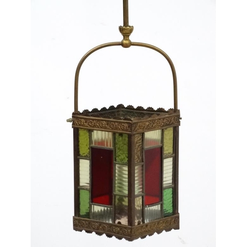 284 - An Edwardian brass and leaded stained glass multicoloured pendant hall lantern / light shade. The wh... 