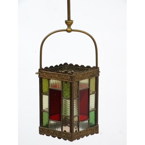 284 - An Edwardian brass and leaded stained glass multicoloured pendant hall lantern / light shade. The wh... 