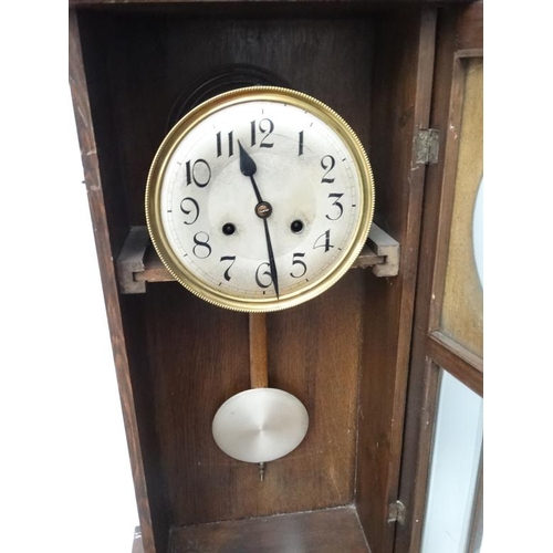 301 - 1930's Oak cased Wall Clock : an 8 day pendulum clock  with pine cone logo , striking on a coiled go... 