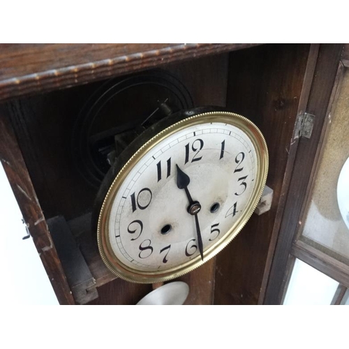 301 - 1930's Oak cased Wall Clock : an 8 day pendulum clock  with pine cone logo , striking on a coiled go... 